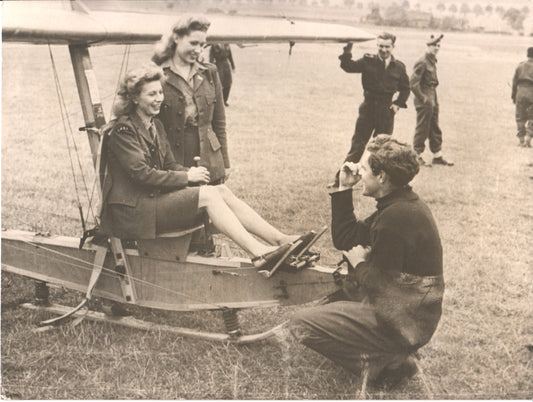 Two women in military uniforms pose in a vintage aircraft for a black-and-white photograph. - Image: Folder12-3